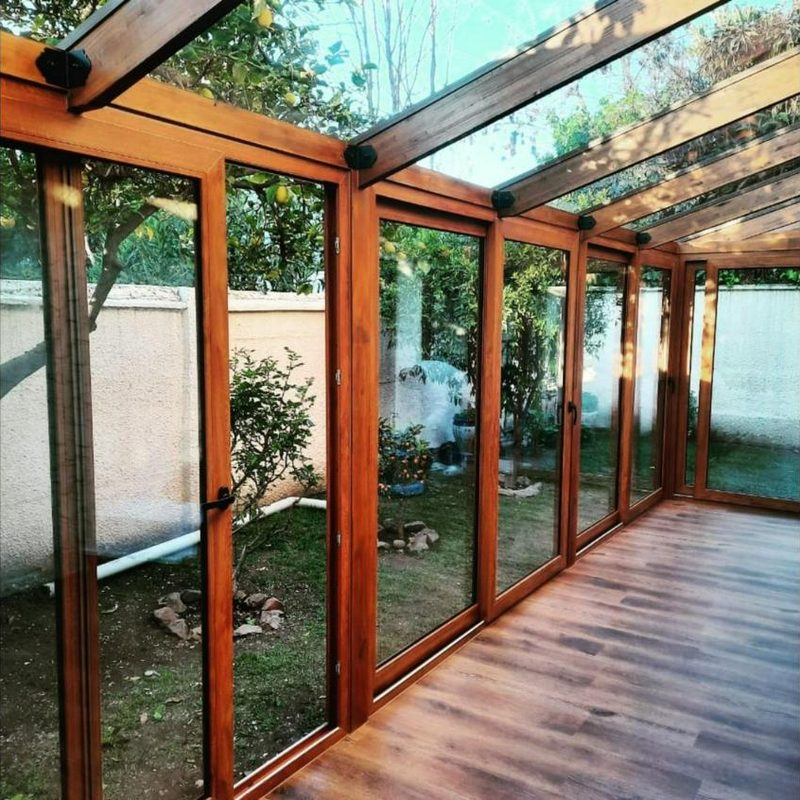 Cerramiento con ventanas de PVC color roble dorado y techo de vidrio